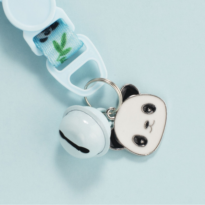 Close-up of a Cat Collar bell, panda-face charm and metal attachment ring