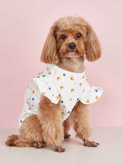 Ozzie dog in ruffle t-shirt standing on grass with a playful expression