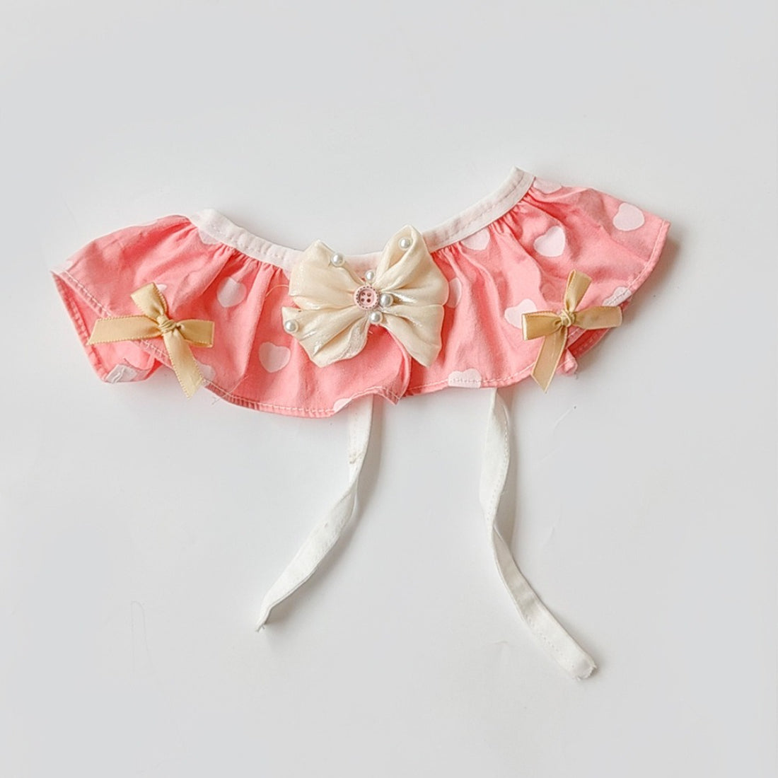 Close-up of heart-shaped bow detail on Mokka cat bib