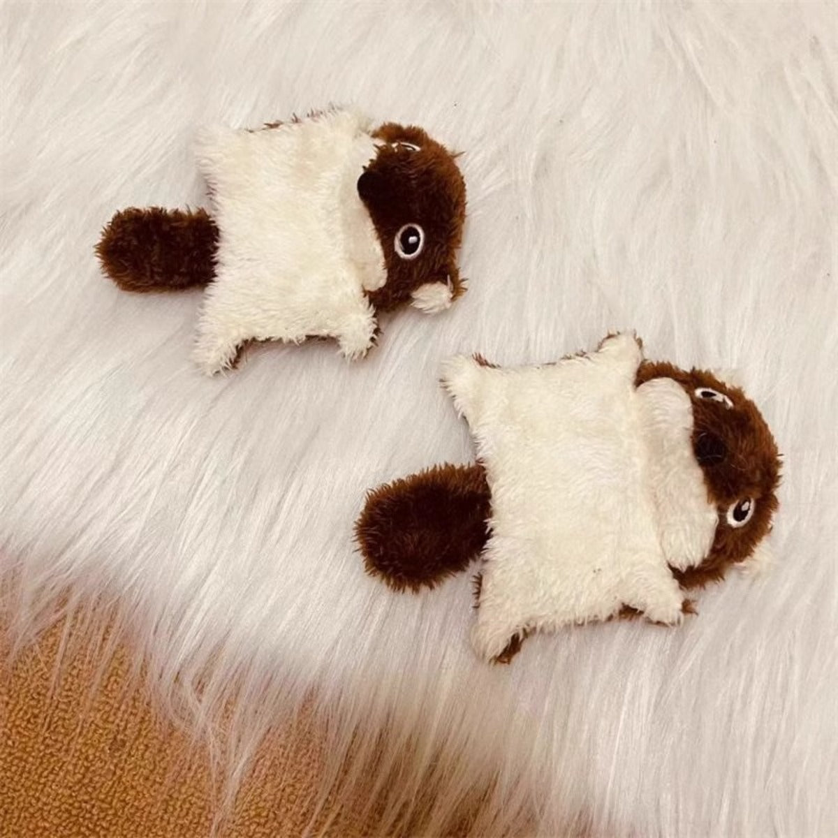 Plush squirrel kicker cat toy lying on a white surface with visible stitching