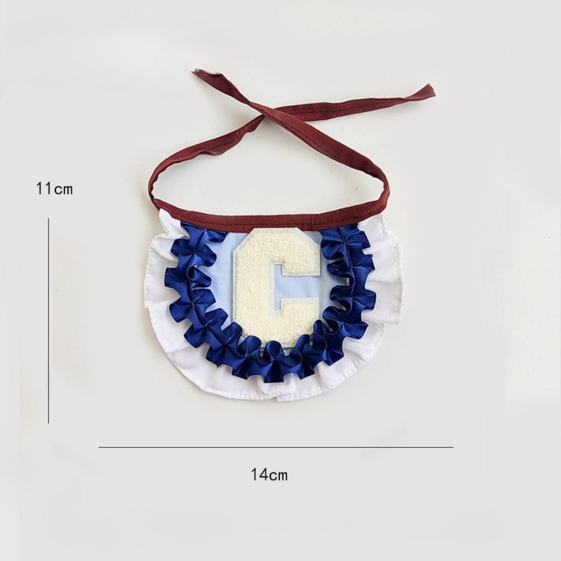 Close-up of Mokka pleated letter cat collar showing detailed stitching and bell