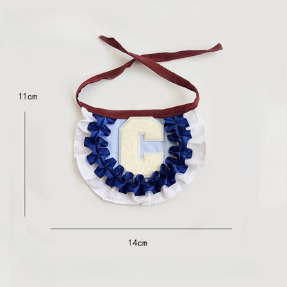 Close-up of Mokka pleated letter cat collar showing detailed stitching and bell