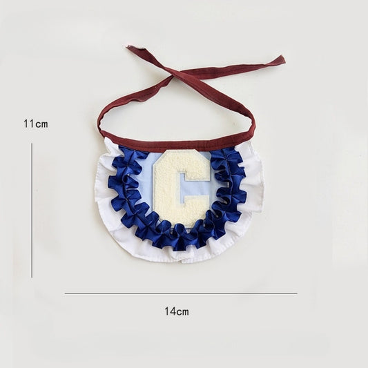Close-up of Mokka pleated letter cat collar showing detailed stitching and bell