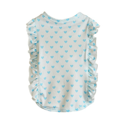 Ozzie dog in heart print ruffle t-shirt sitting on gray carpet with white wall background