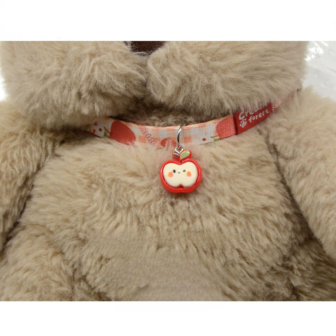 Mokka cat collar displayed flat highlighting the apple charm and leather texture