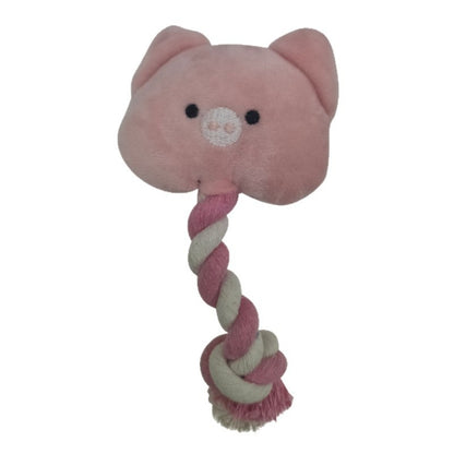Dog playing with pink pig rope toy, gripping it in its mouth