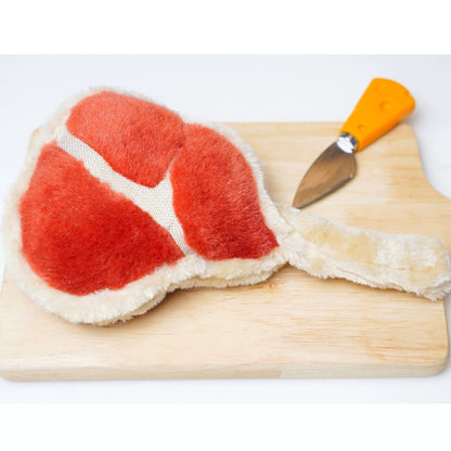 Plush ham dog toy lying flat showing embroidered details and soft texture