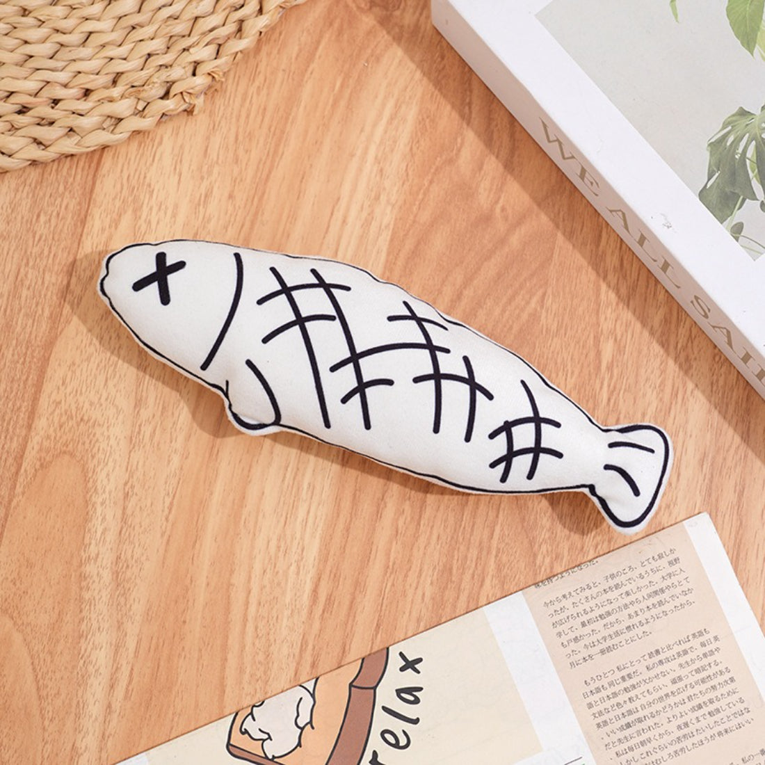 Moo plush cat toy held in hand to show size and lightweight nature