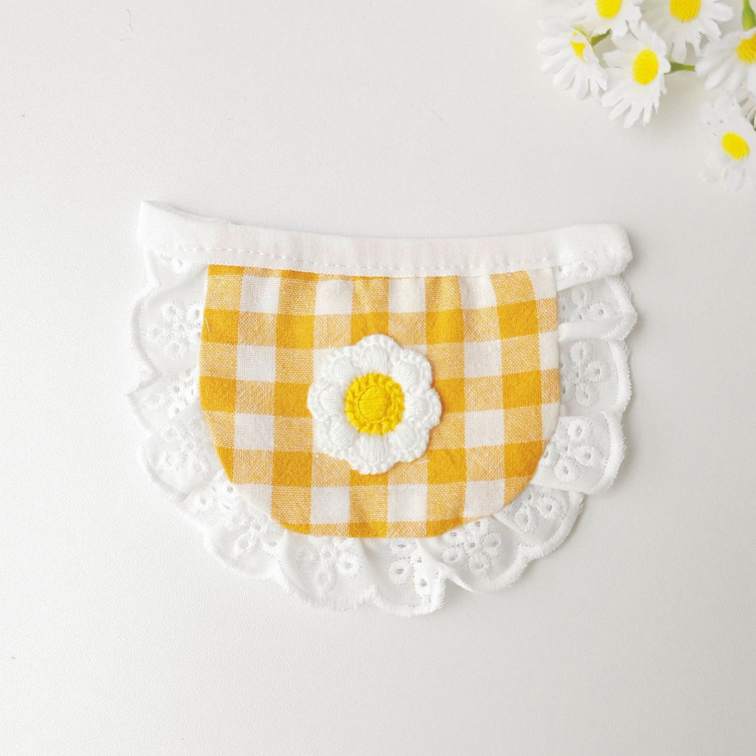 Mokka gingham daisy cat bib worn by a cat, showing fit and style