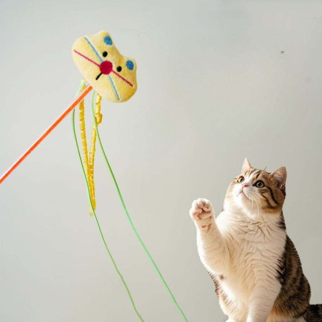 Moo plush cat teaser wand held by a hand demonstrating size and flexibility