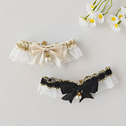 Cat wearing Mokka lace bow charm collar, sitting on wooden floor