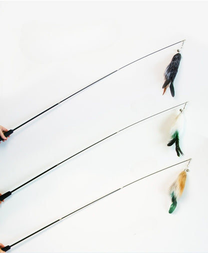 Moo Classic Feather Extendable Cat Teaser Wand coiled with feathers on a plain surface