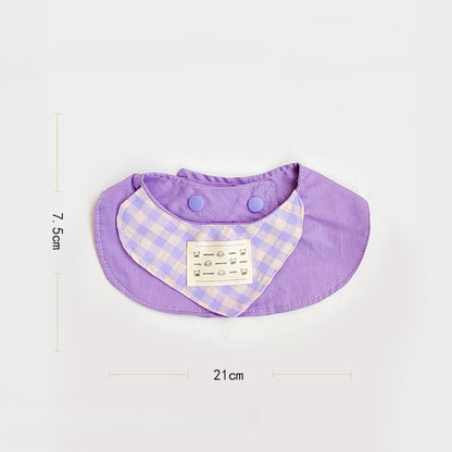 Close-up of pastel gingham cat bib showing soft fabric texture and stitched edges