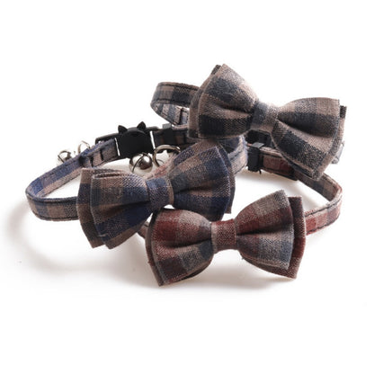 Mokka cat collar featuring soft plaid bow tie and bell on a flat surface