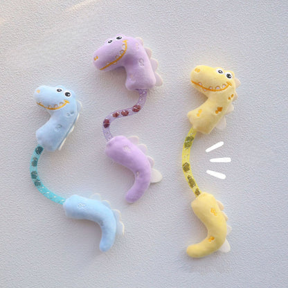 Close-up of Moo Dinosaur cat toy showing shimmering green fabric and stitched details