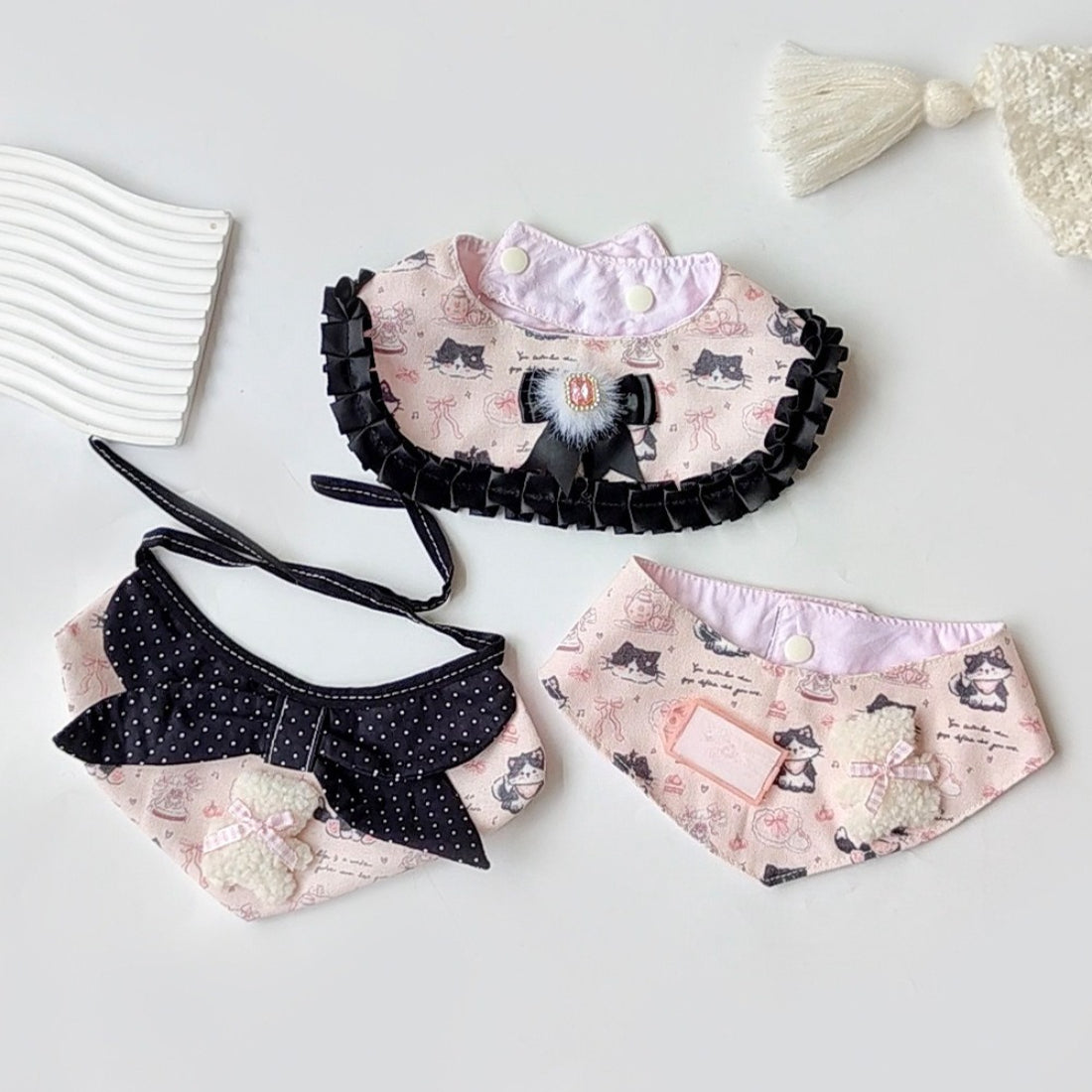 Pink neck bib with cartoon cat face and ears, designed for babies