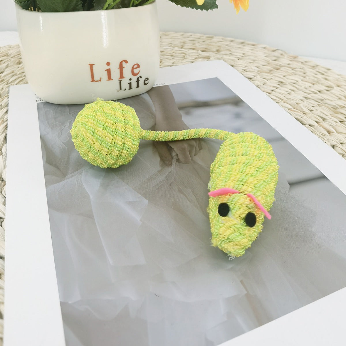 Moo cat toy with long tail placed on wooden floor with natural light