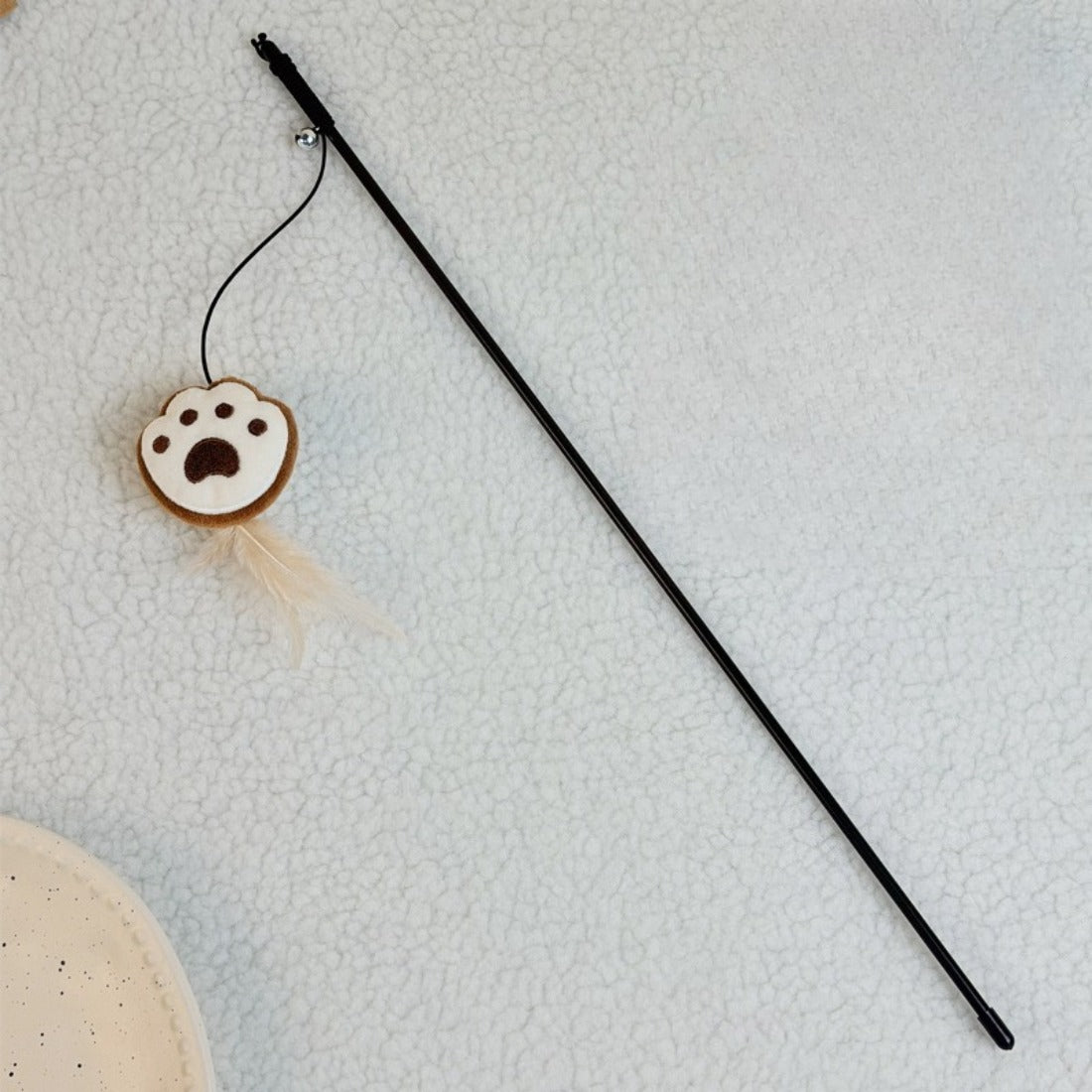 Side angle of the Moo Cookie plush cat teaser wand highlighting the plush and feathers