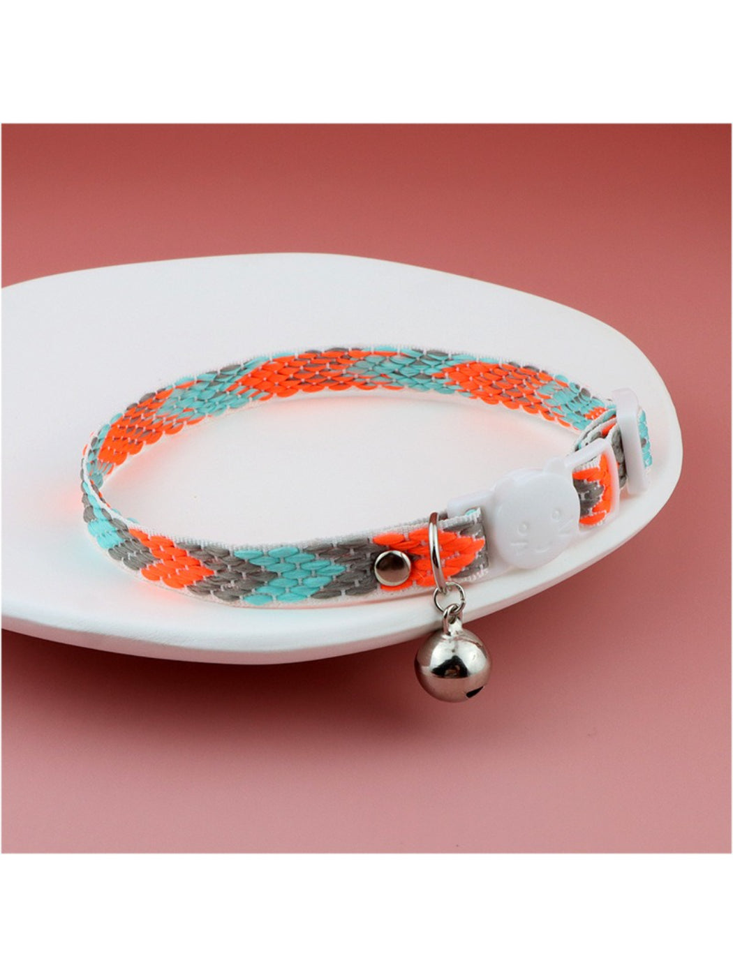 Close-up of bright geometric cat collar showing buckle and metal D-ring