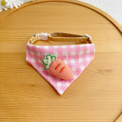 Cat wearing pink gingham bandana sitting on wooden floor