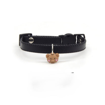 Brown leather breakaway cat collar with attached bear charm displayed flat