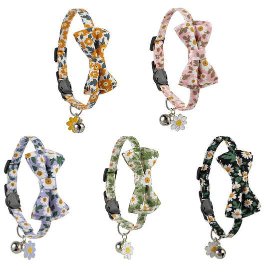 Close-up of Mokka floral bowtie cat collar with pink and white flowers on fabric