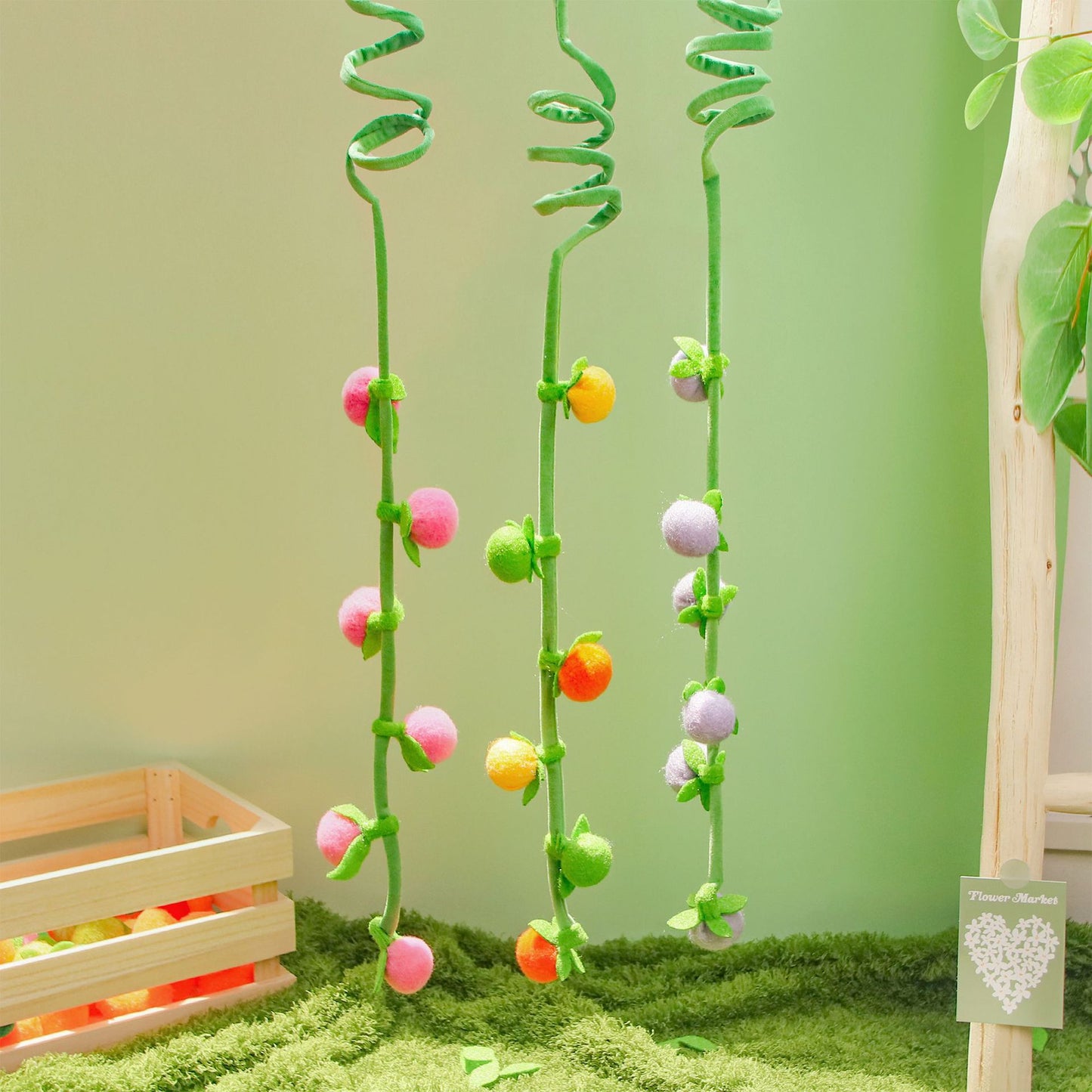 Moo hanging fruit vine cat toy with colorful fruits hanging from a vine on a plain background