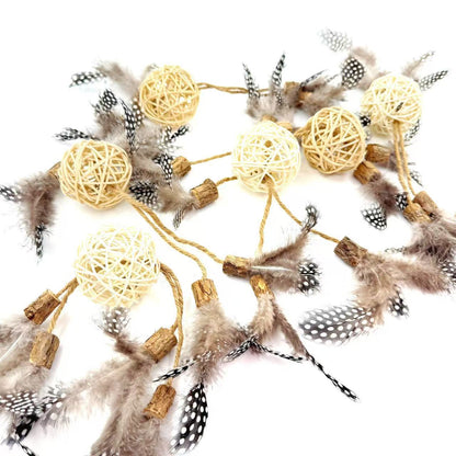 Close-up of natural rattan cat toy balls featuring feather and silvervine elements