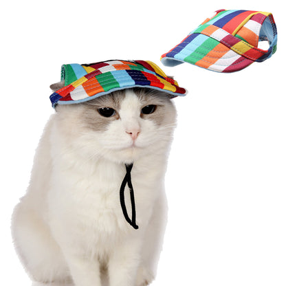 Small dog looking up wearing Ozzie visor cap in outdoor setting