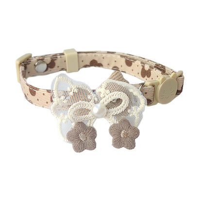 Mokka bow cat collar with floral charm displayed on wooden surface