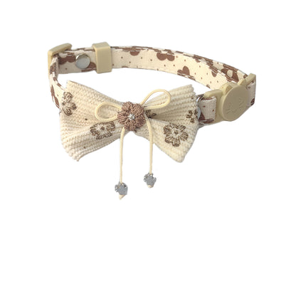 Mokka bow cat collar with floral charm next to matching pet accessories