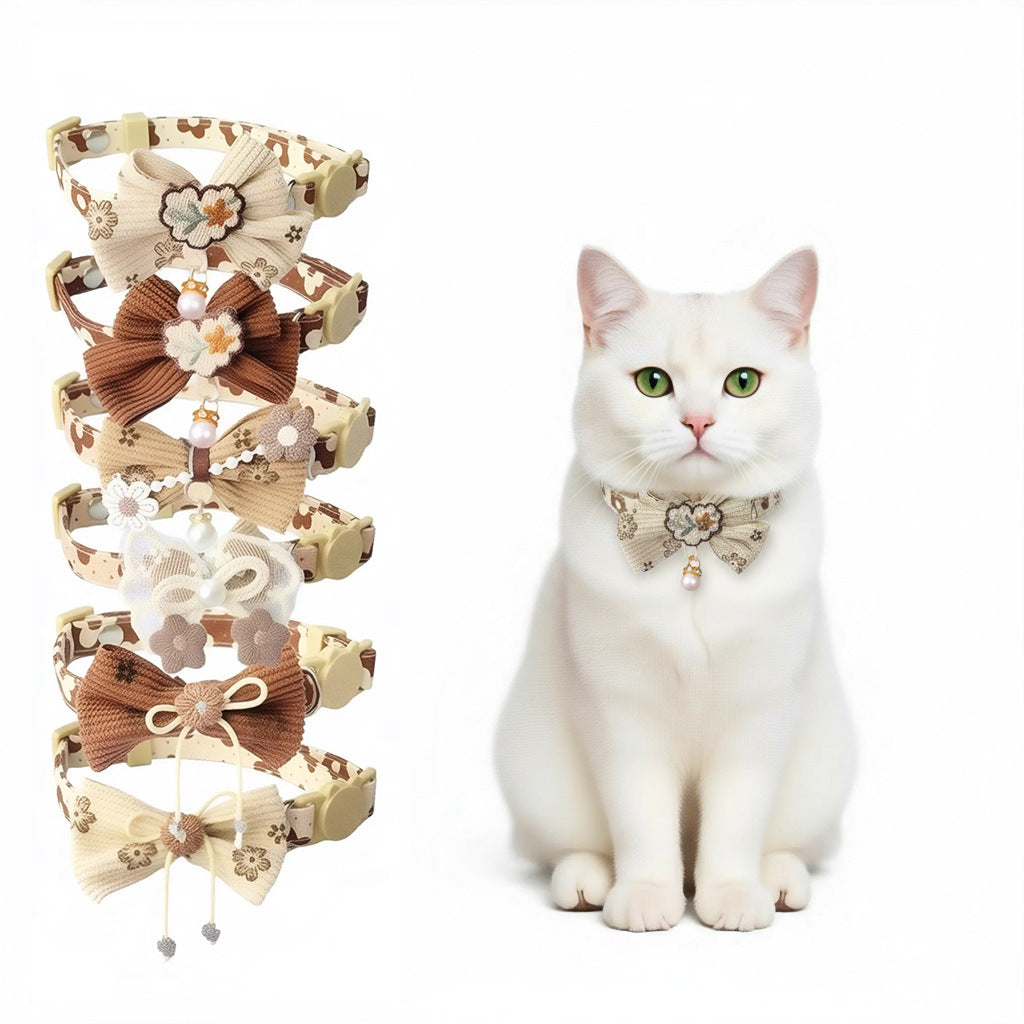 Close-up of Mokka bow cat collar with pink floral charm on white background