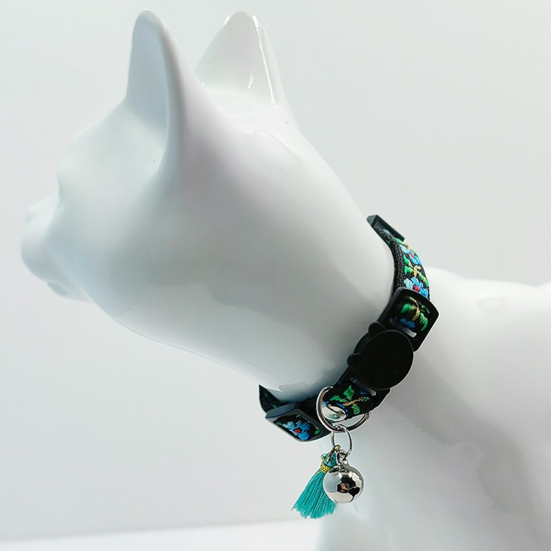 Mokka colorful floral cat collar with tassel and bell close-up on fabric