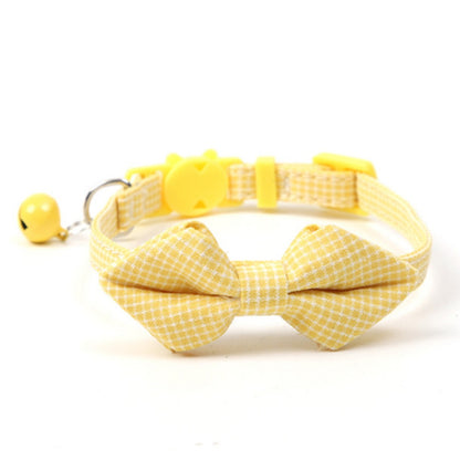 Mokka gingham bow tie cat collar with bell laid out on wooden surface