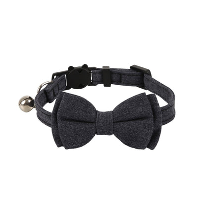 Mokka cat collar with solid color bow and bell laid flat on surface