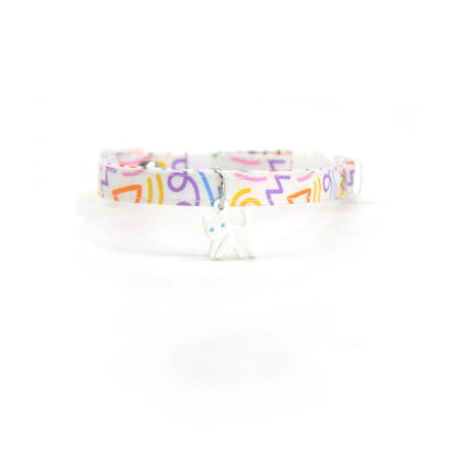 Close-up of silver abstract cat charm attached to black breakaway collar