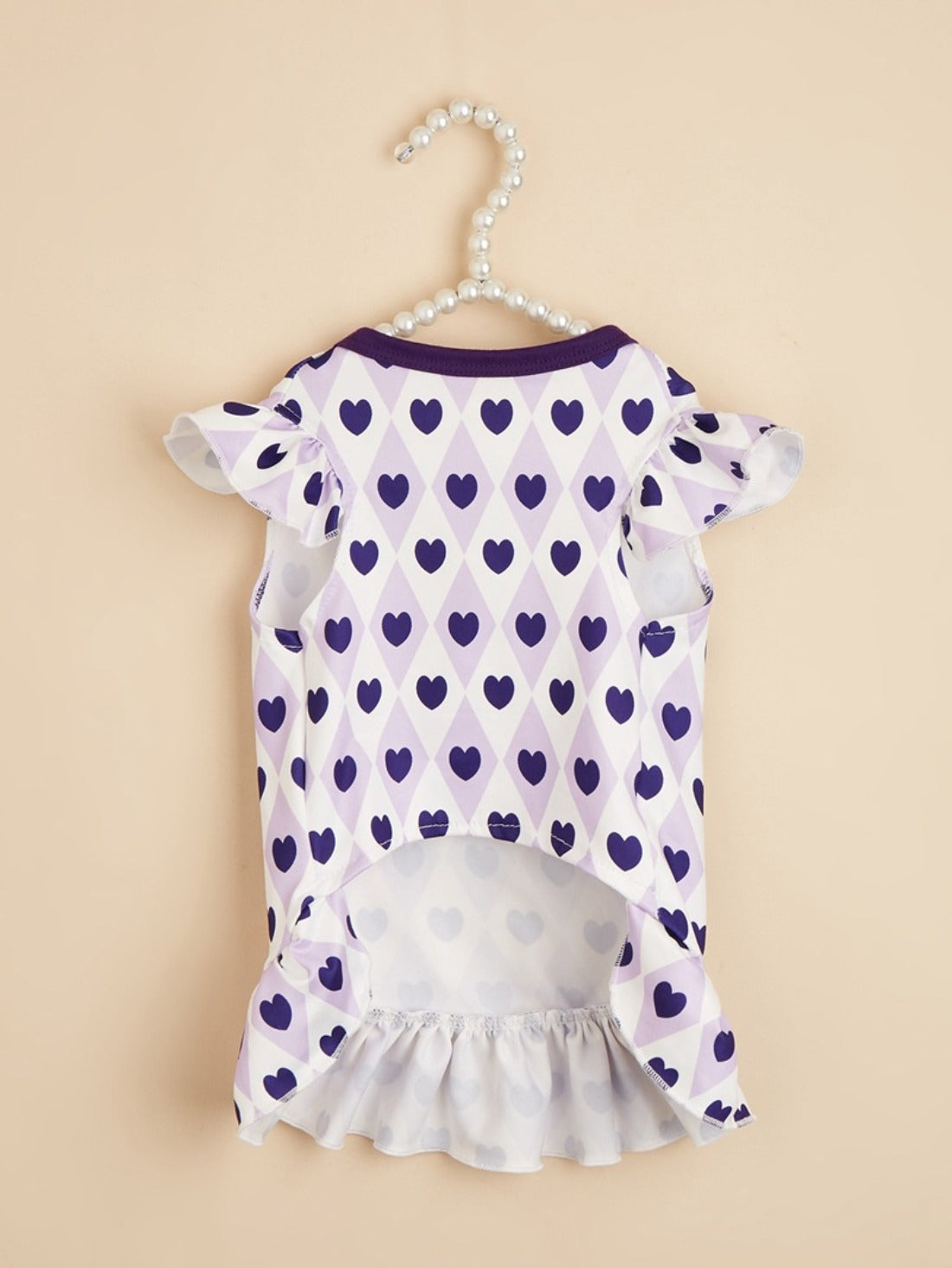 Ozzie dog dress with red hearts displayed on small dog against plain background
