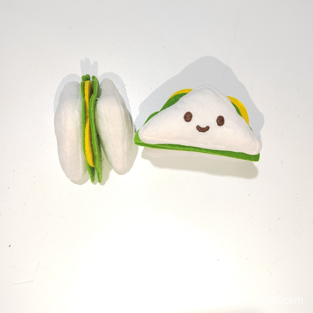 Moo plush hamburger cat toy with a smiling face and soft, cuddly appearance