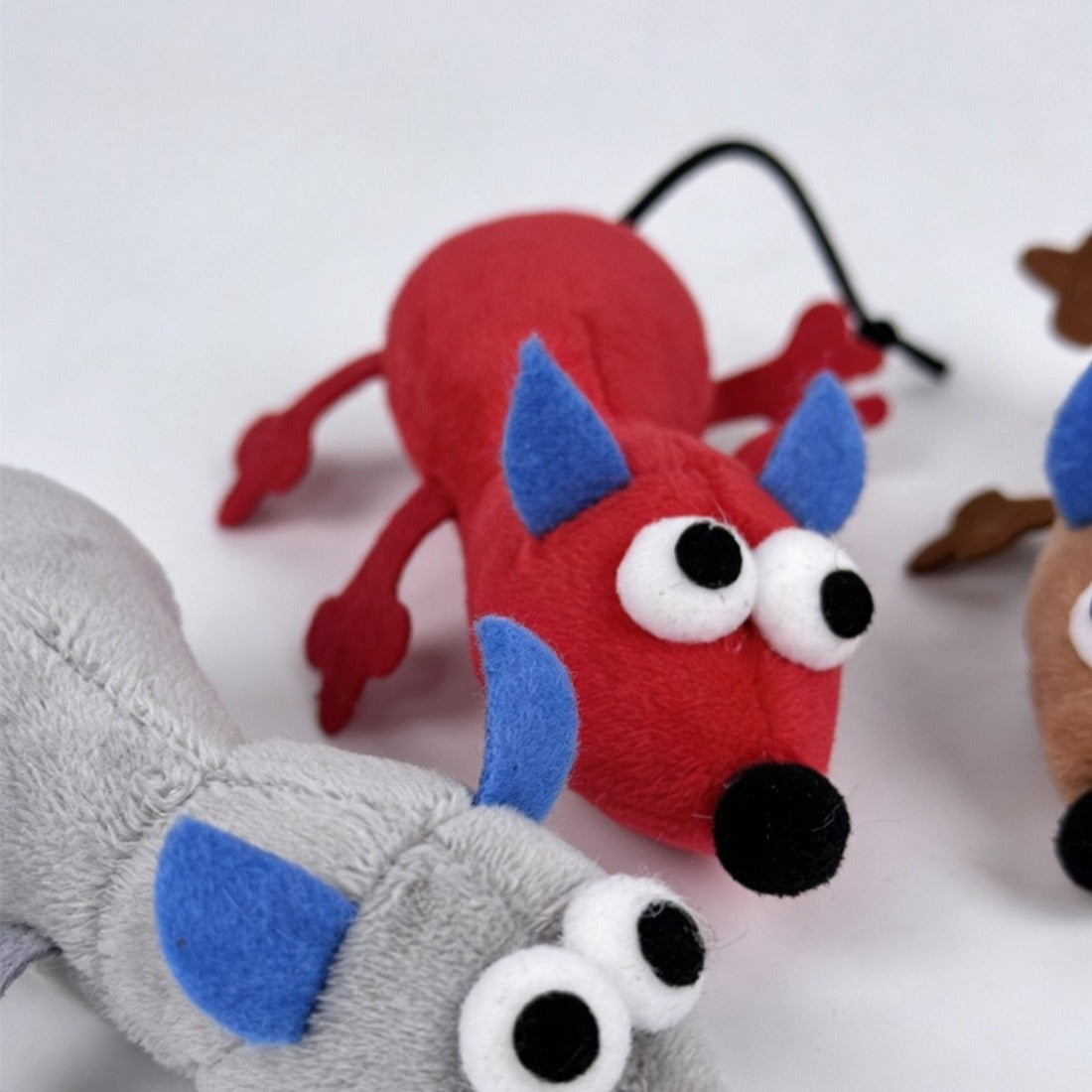 Moo mouse cat toy next to a cat paw reaching to play