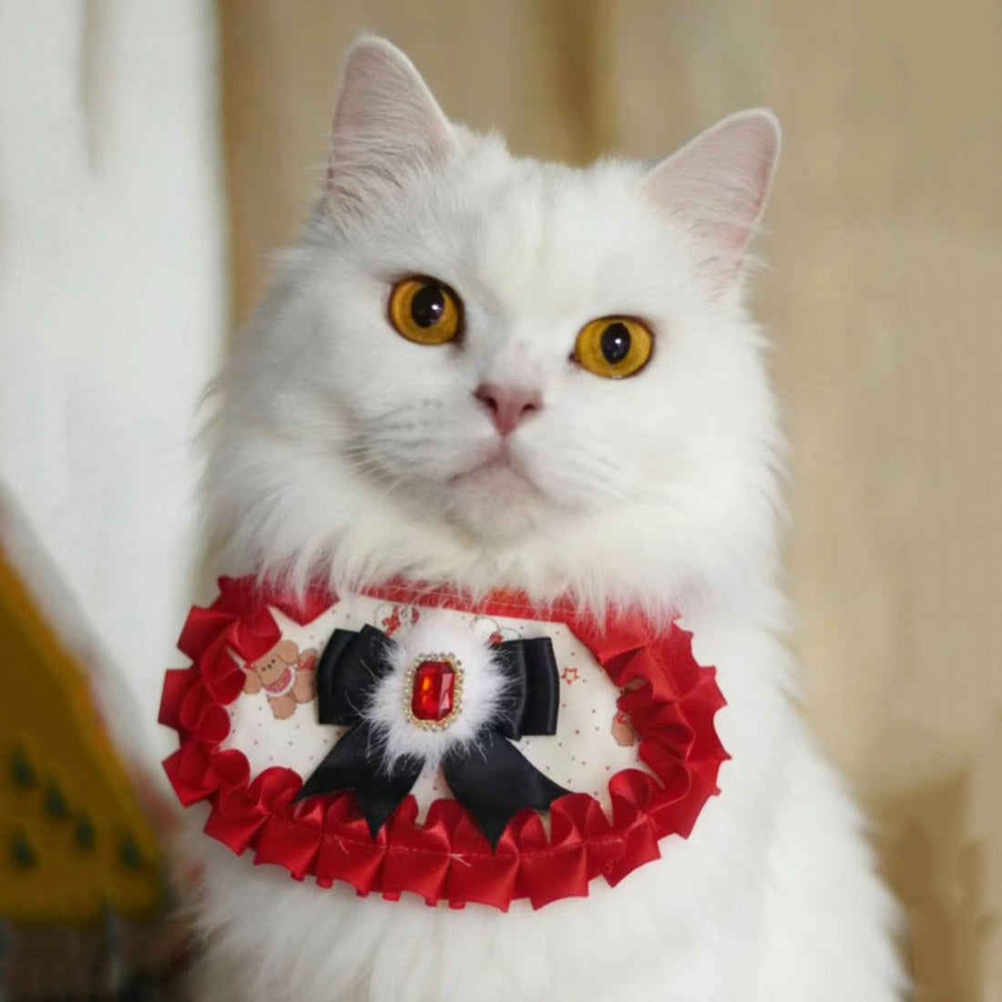 Mokka ruffle gem cat neck bib in soft beige with decorative gem and ruffled edges