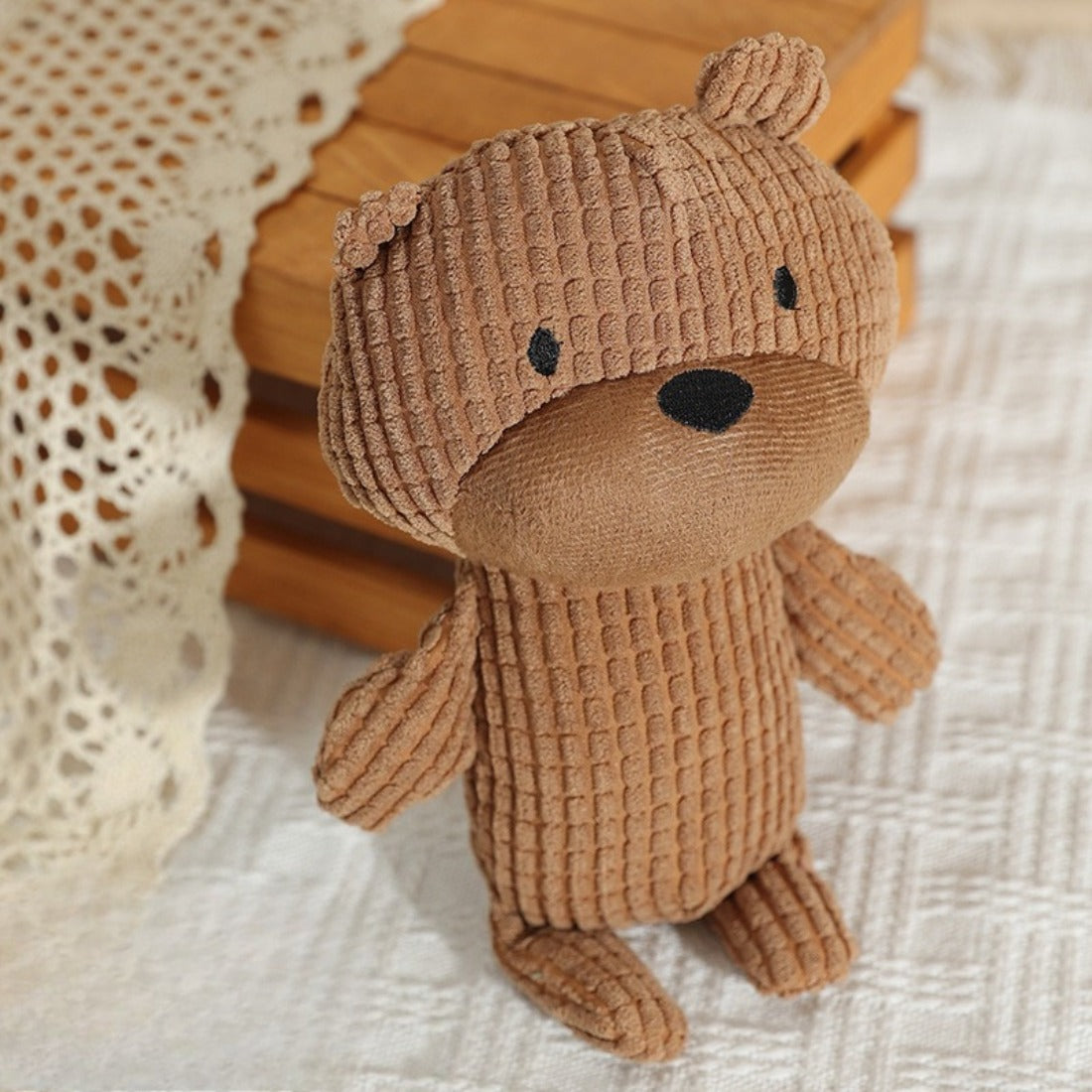 Petkin bear plush dog toy held in hand to show size and soft texture