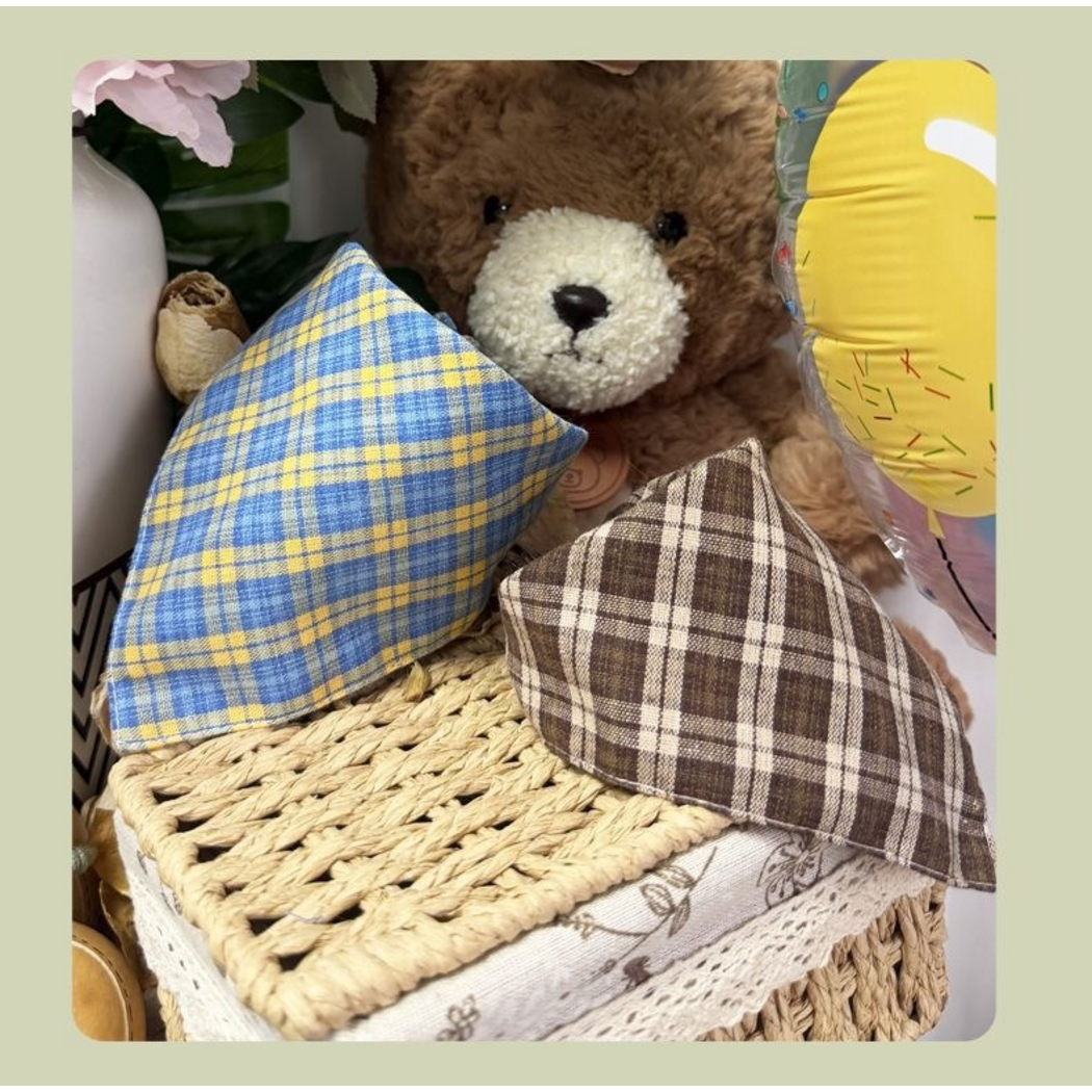 Blue and Brown plaid pet neckwear displayed together on a woven basket