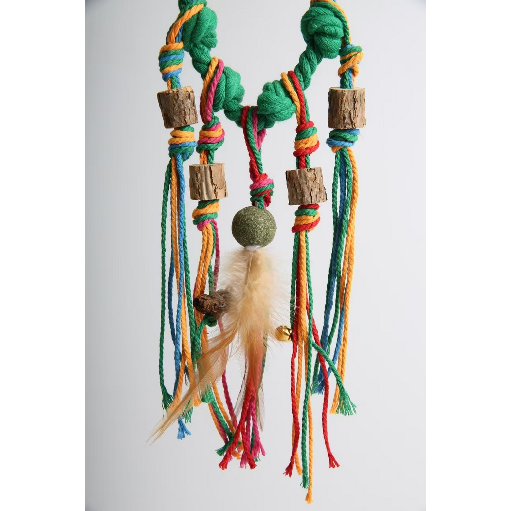 Green knotted rope cat toy hanging vertically with long multicolored tassels
