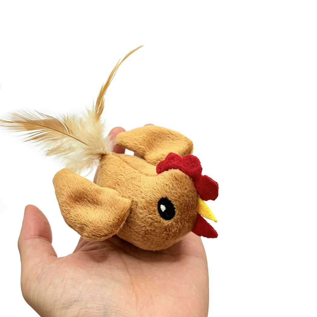 Rooster cat toy resting on an open hand, showing its eye, wings and feather tail