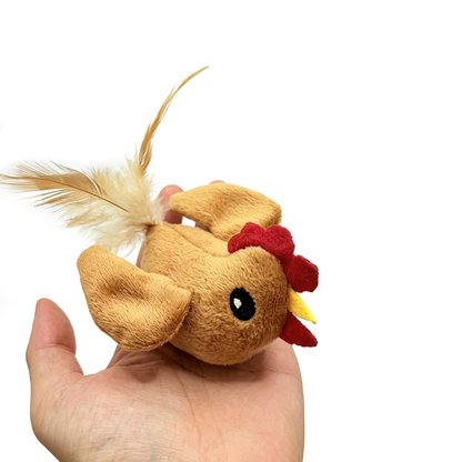 Rooster cat toy resting on an open hand, showing its eye, wings and feather tail