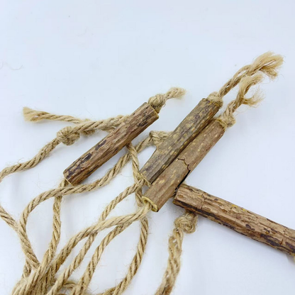 Close-up of mottled brown sticks and twisted tan cords with knots and frayed ends