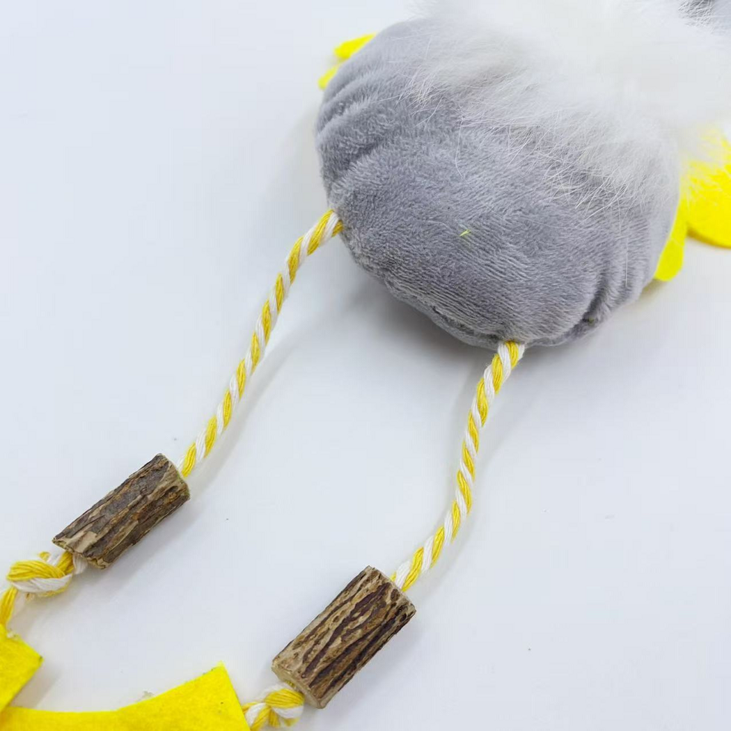 Duck cat toy leg detail showing yellow-and-white twisted cords, knots and brown bark-textured pieces