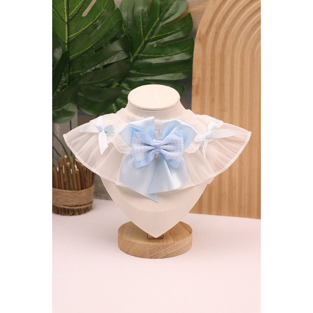 Blue Pet Neckwear with a layered central bow, pale blue side bows and white ruffled edging on a stand