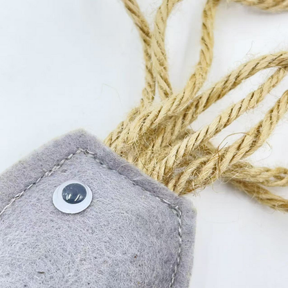 Close-up of the round eye, gray fibrous surface, stitched edge and tan cord attachment
