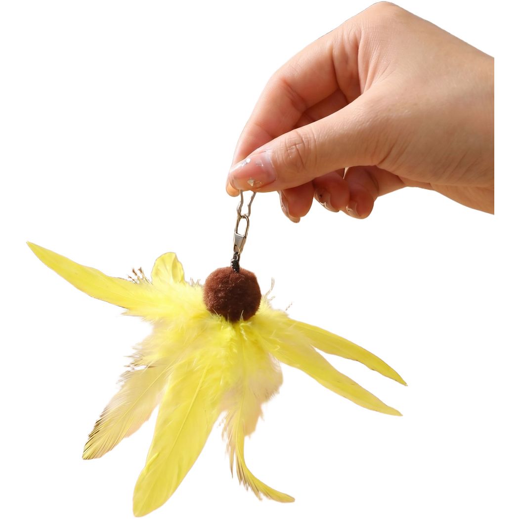 Yellow feather cat toy hanging from its metal clip held between fingers